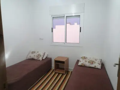 a room with two beds and a window at Aicha appartement 2 in Meknès
