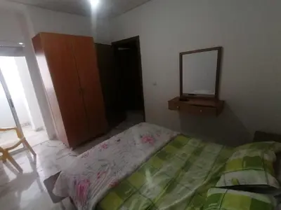 a bedroom with a bed and a mirror and a dresser at Aicha appartement 2 in Meknès