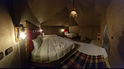 a bedroom with a large bed in a tent at fabulousluxurycamp in Merzouga