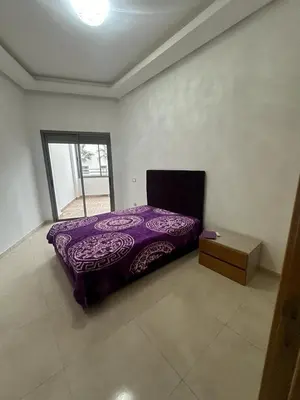 a purple bed in a room with a box at Mansbay Beach in Oulad Akkou