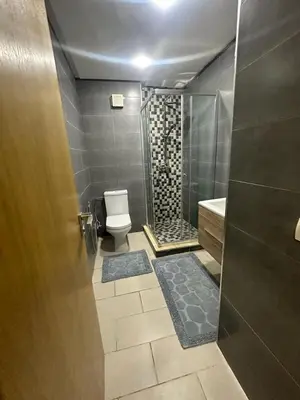 a bathroom with a toilet and a glass shower at Mansbay Beach in Oulad Akkou