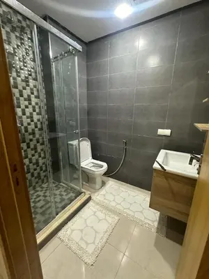 a bathroom with a shower and a toilet and a sink at Mansbay Beach in Oulad Akkou