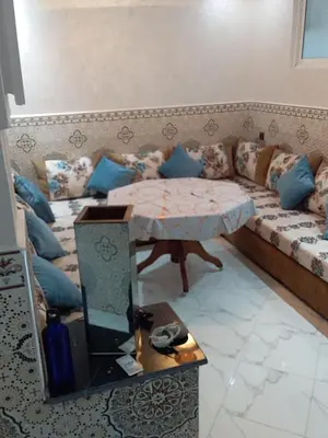 a living room with a couch and a table at Appartement A Martil in Oulad Akkou