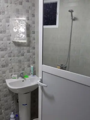 a bathroom with a white sink and a shower at Appartement A Martil in Oulad Akkou