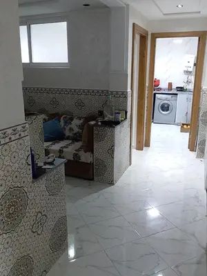a living room with a couch and a tile floor at Appartement A Martil in Oulad Akkou