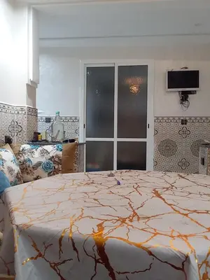 a bedroom with a bed and a television in it at Appartement A Martil in Oulad Akkou
