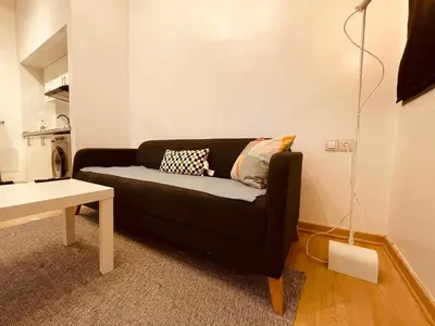 a living room with a black couch and a table at Relax Family 01 - Cozy Entire Apartement in City Center in Ouarzazate