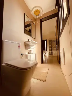 a bathroom with a toilet and a mirror on the wall at Relax Family 01 - Cozy Entire Apartement in City Center in Ouarzazate
