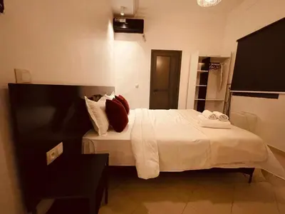 a bedroom with a bed with white sheets and pillows at Relax Family 01 - Cozy Entire Apartement in City Center in Ouarzazate