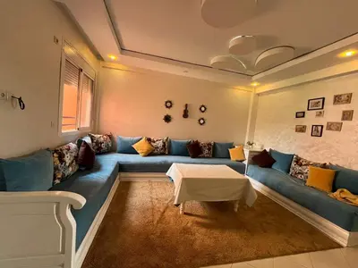a living room with a blue couch and a table at Appartement in Beni Mellal