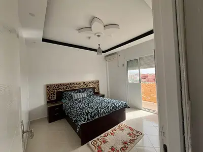 a bedroom with a bed and a large window at Appartement in Beni Mellal