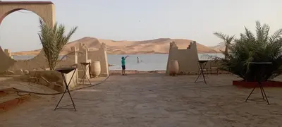 a man standing in front of a body of water at Auberge merzouka in Rissani