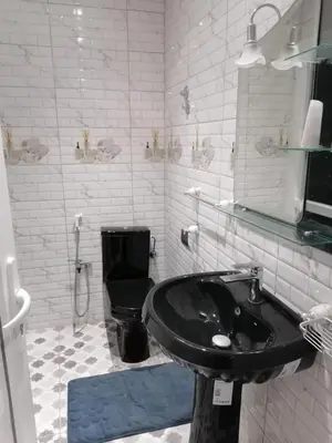 a bathroom with a black sink and a toilet at Elbatoir in Oulad Akkou