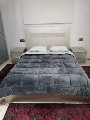 a bedroom with a large bed with two night stands at Elbatoir in Oulad Akkou