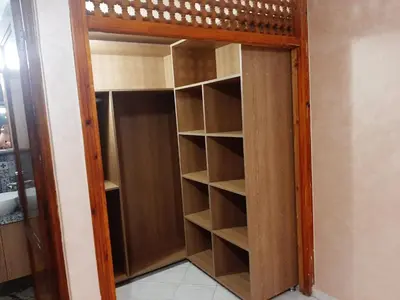 a closet with wooden shelves in a room at Chokri lamia in Ouled Khellouf
