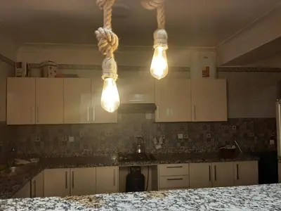 a kitchen with white cabinets and two lights at Chokri lamia in Ouled Khellouf