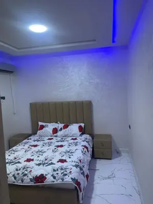 a bedroom with a bed and a blue wall at AMB appartements in Oulad Akkou