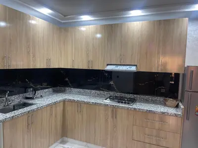 a kitchen with wooden cabinets and a counter top at AMB appartements in Oulad Akkou