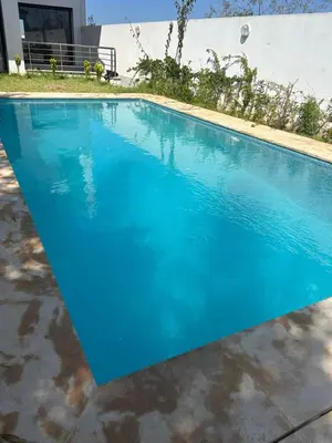 a swimming pool with blue water in a yard at villa prestigieuse avec piscine in Oulad Akkou