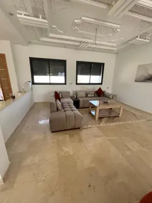 a living room with a couch and a table at villa prestigieuse avec piscine in Oulad Akkou