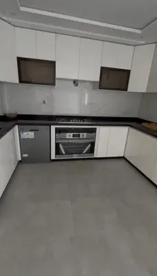 an empty kitchen with white cabinets and a stove at villa prestigieuse avec piscine in Oulad Akkou