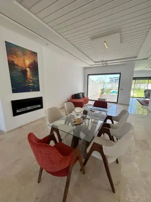 a dining room with a glass table and chairs at villa prestigieuse avec piscine in Oulad Akkou