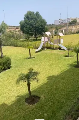 a playground in a park with a palm tree at Paysage del Costa in Oulad Akkou