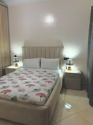 a bed in a bedroom with two night stands and two lamps at Appartement Marrakech in Oulad Akkou