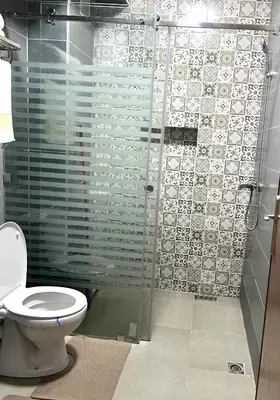 a bathroom with a toilet and a glass shower at Appartement Marrakech in Oulad Akkou