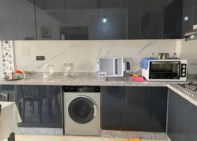 a kitchen with a washing machine and a microwave at Appartement Marrakech in Oulad Akkou
