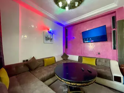 a living room with a couch and a table at Le meilleur appartement à côté du grand stade sportif de Fès in Fès
