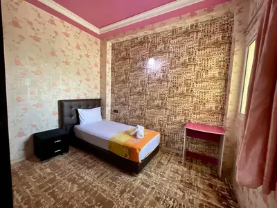 a bedroom with a bed and a brick wall at Le meilleur appartement à côté du grand stade sportif de Fès in Fès