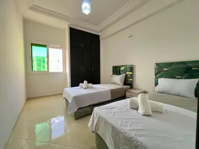 a bedroom with two beds and a window at Residence Nasr Fes - Family & Traveler Apartments in Fès