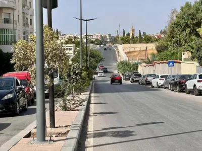 a street with cars parked on the side of the road at Residence Nasr Fes - Family & Traveler Apartments in Fès