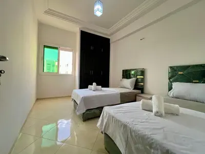 a bedroom with two beds and a window at Residence Nasr Fes - Family & Traveler Apartments in Fès