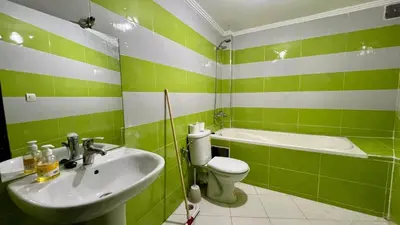 a green and white bathroom with a sink and a toilet at Residence Nasr Fes - Family & Traveler Apartments in Fès