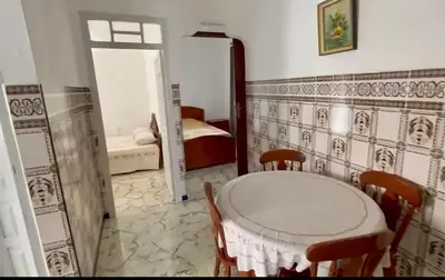a room with a table and chairs and a bedroom at Appartement Martil in Oulad Akkou