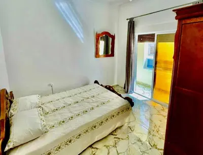 a bedroom with a bed and a window at Appartement Martil in Oulad Akkou