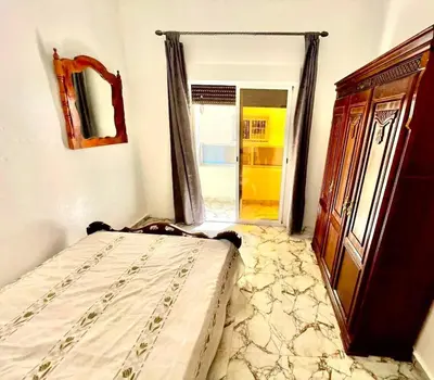 a bedroom with a bed and a door to a doorway at Appartement Martil in Oulad Akkou