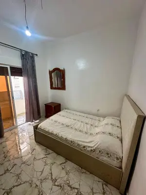 a bedroom with a bed in the corner of a room at Appartement Martil in Oulad Akkou