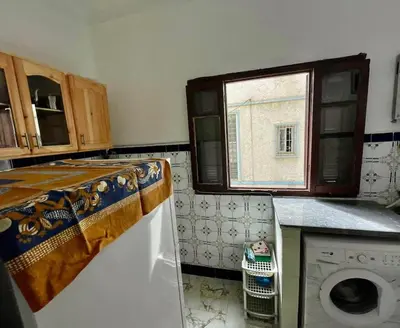 a kitchen with a washing machine and a window at Appartement Martil in Oulad Akkou