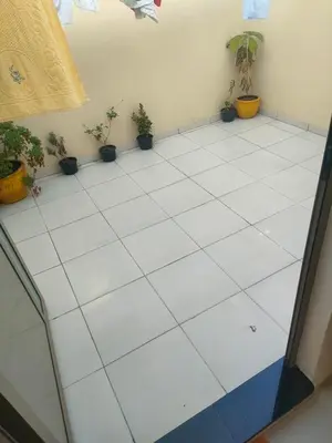 a room with potted plants on a white tiled floor at Dar essaouira in Oulad Akkou