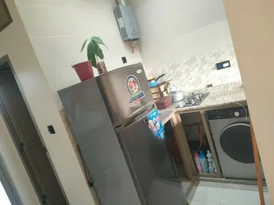 a kitchen with a stainless steel refrigerator and a washing machine at Dar essaouira in Oulad Akkou