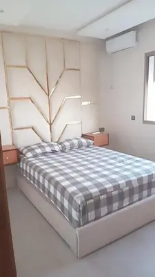 a bedroom with a large bed with a checkered blanket at إقامة ياسمينه in Oulad Akkou