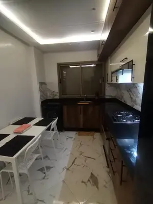 a kitchen with a counter and a table and a counter top at إقامة ياسمينه in Oulad Akkou