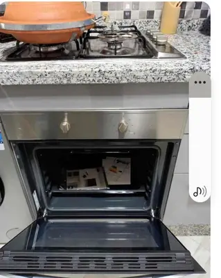an open oven in a kitchen next to a stove at Appartement martil in Oulad Akkou