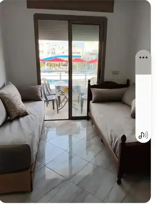a living room with a couch and a view of a patio at Appartement martil in Oulad Akkou