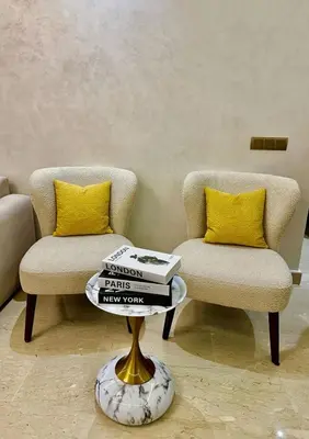 two chairs and a coffee table with books on it at Le Scandinave de Marrakech-Gueliz-Centre in Oulad Akkou