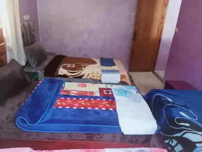 a bedroom with a bed with a quilt on it at Gîte Ayour Atlas Tachddirt in Tacheddirt