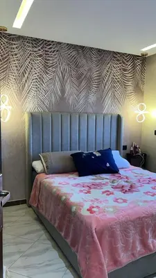 a bedroom with a large bed with a pink blanket at عمارة المودة 2 in Oulad Akkou